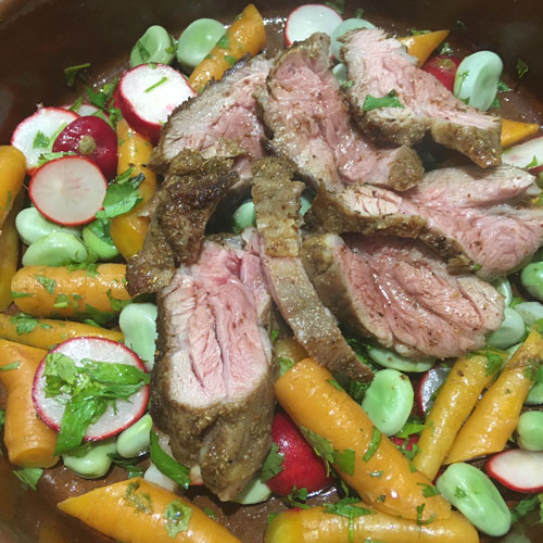 sliced lamb on vegetable salad